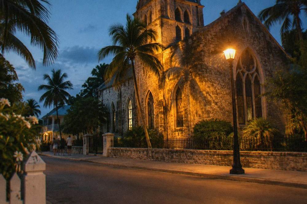 Historic Key West church facade and quiet street lit by street lamps at night