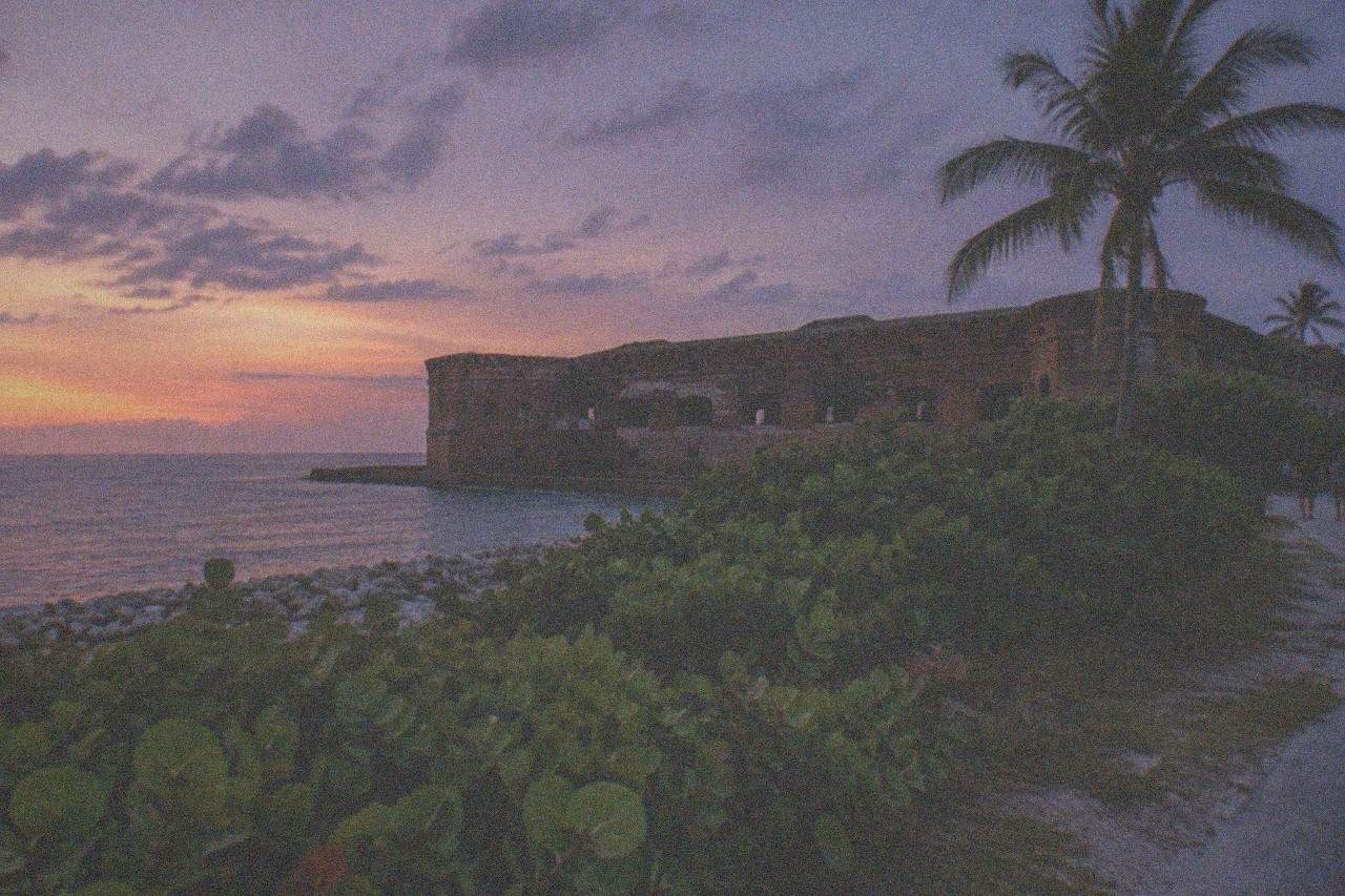 A Civil War era brick fort museum beside a coastal road at dusk