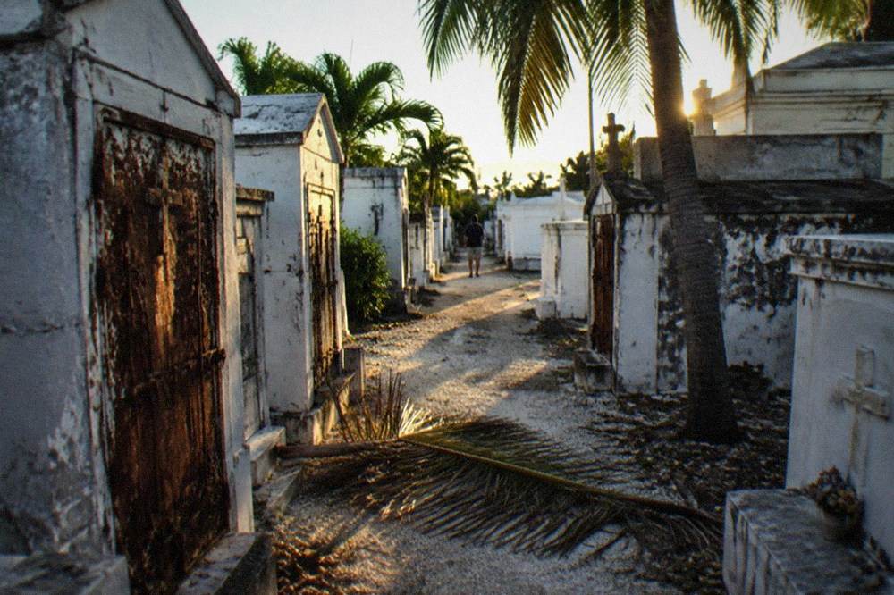 A narrow path between old above-ground tombs in late afternoon light