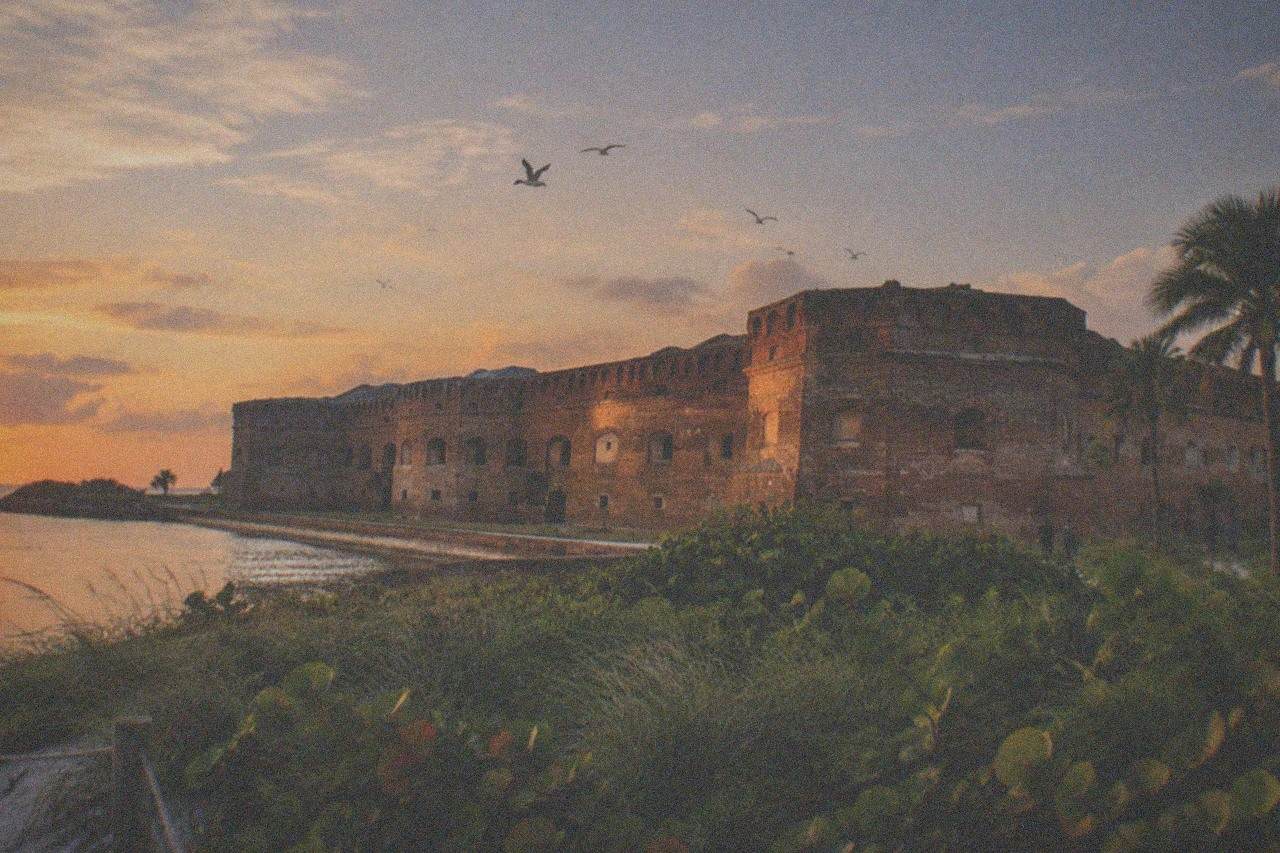 An old brick fort by the water under an evening sky
