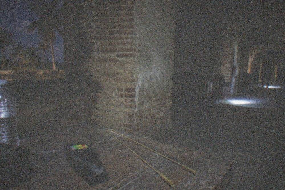 A darkened museum gallery at night with ghost hunting equipment resting on a table