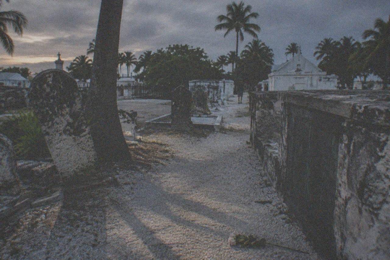 Old weathered cemetery headstones leaning under evening light in Key West