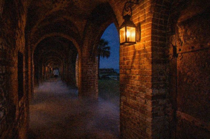 A lantern-lit brick casemate at Fort East Martello at night, ready for a ghost hunt