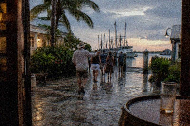 A guide leading a haunted pub crawl group toward a lamplit Key West bar door at night
