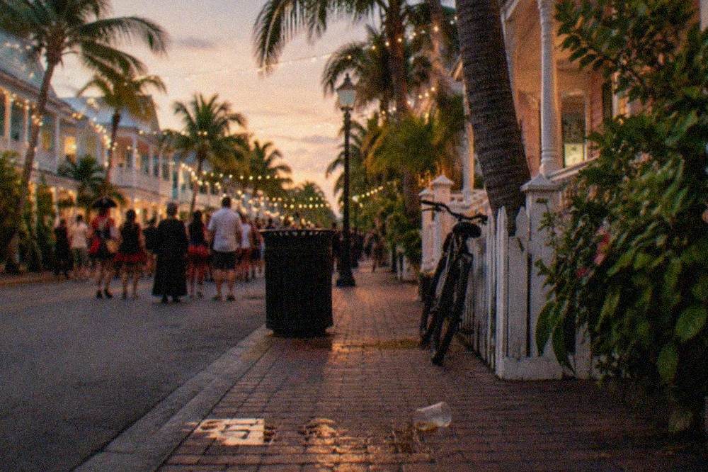 Evening crowd gathered under string lights on a busy Key West street during festival season