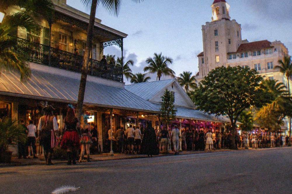 Costumed revelers and lantern light on a crowded Duval Street during an October festival night