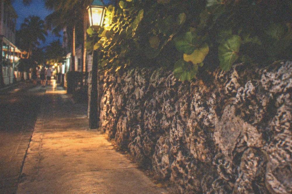 Lantern light glowing on a narrow Old Town street beside coral rock walls
