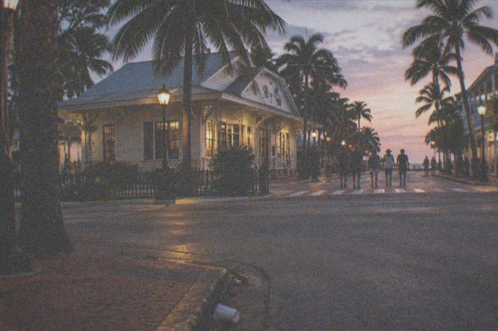 Evening crowd crossing a lamplit Key West intersection near Old Town bars