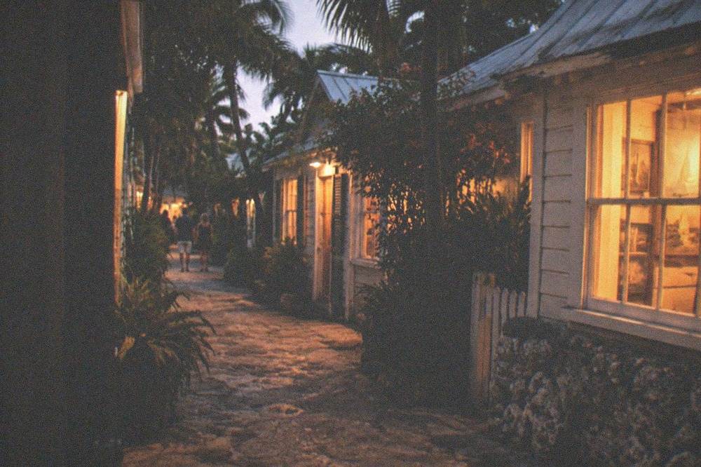 A narrow Old Town lane at night with warm light from gallery windows