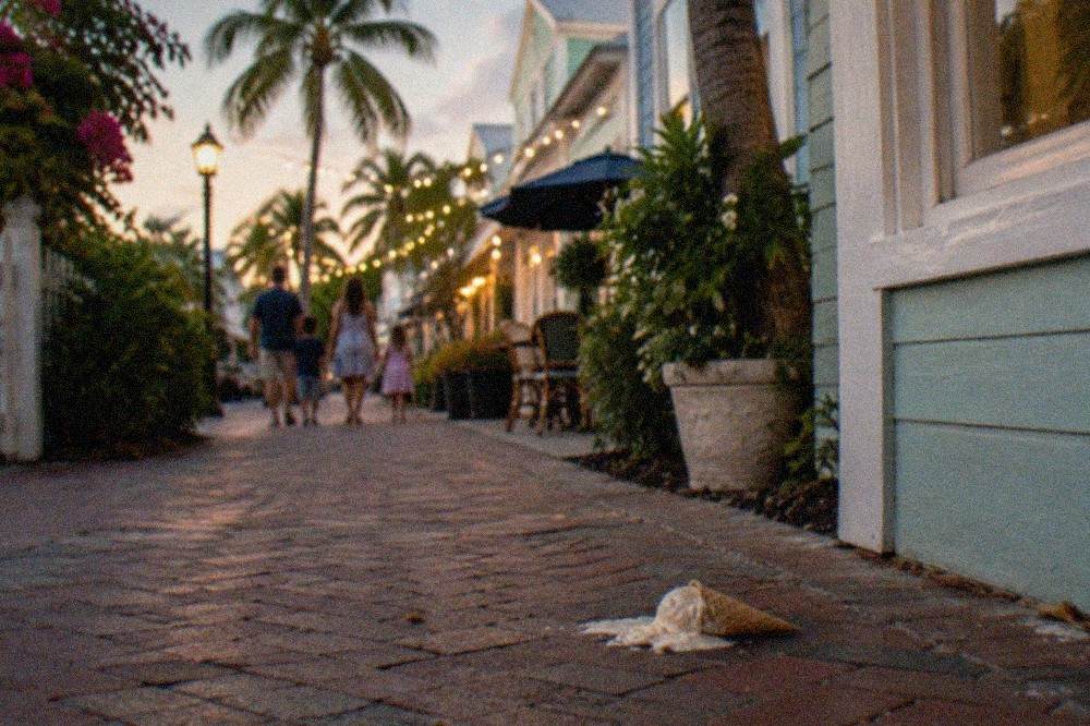 A family-friendly evening walking street in Key West with pastel buildings and strung lights