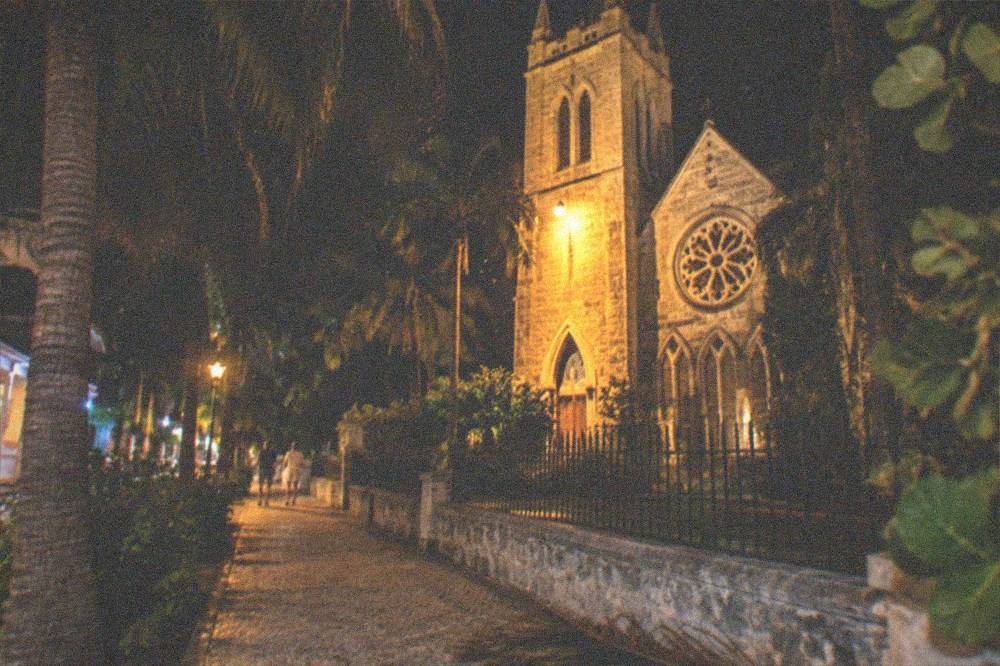A historic church facade lit at night on a quiet Duval Street corner