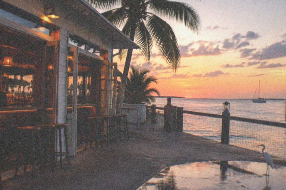 Crowd of bar goers absent, empty stools and open doors of a Duval Street bar at dusk
