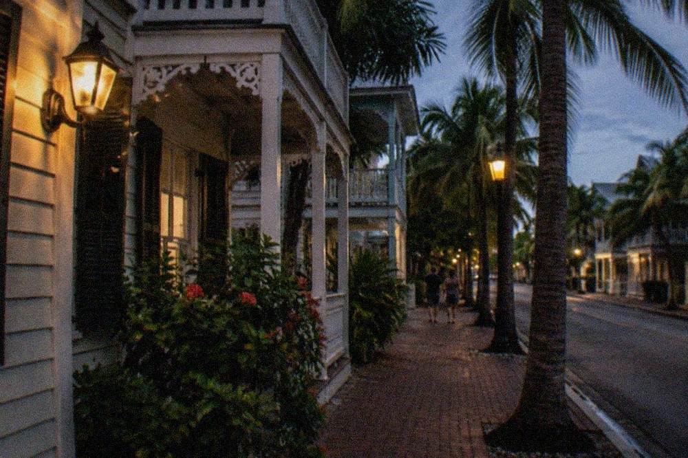 A lamplit Old Town street in Key West with wooden buildings and balconies at night