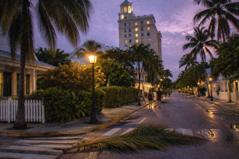 A tall historic hotel tower above Lower Duval Street at night